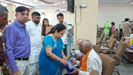 फरीदाबाद में स्वास्थ्य जांच एवं सहायक उपकरण वितरण शिविर में लाभार्थियों को व्हीलचेयर और अन्य उपकरण वितरित करते हुए