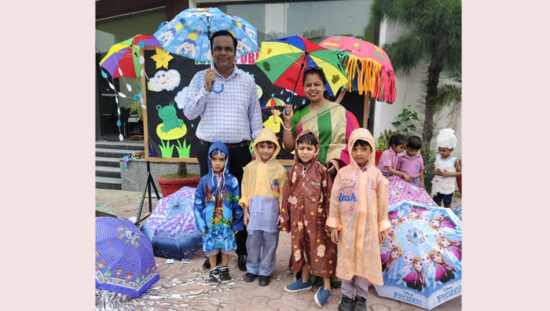 Kindergarten students of Ideal Public School Agwanpur celebrating Rainy Day in colourful raincoats and umbrellas.