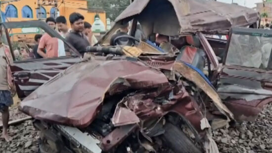 मुर्शिदाबाद में ट्रेन की टक्कर के बाद क्षतिग्रस्त स्कूल वैन और घटनास्थल पर मौजूद राहत-बचाव दल।