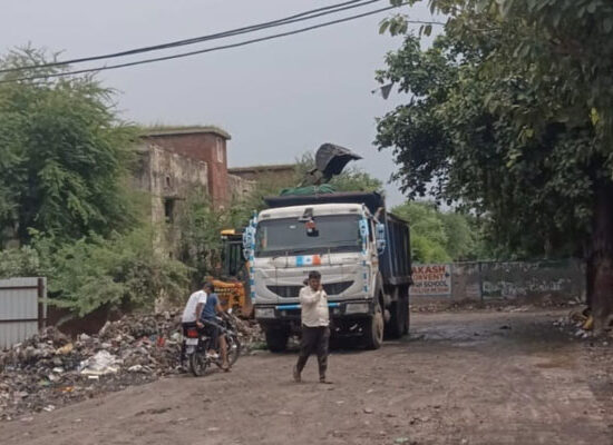 फरीदाबाद में नगर निगम के सफाई अभियान के दौरान कूड़ा उठाते कर्मचारी