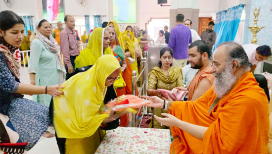 Swami Purushottamacharya Maharaj distributing gifts and blessings to sewadars on Diwali at Shri Siddhidata Ashram Faridabad